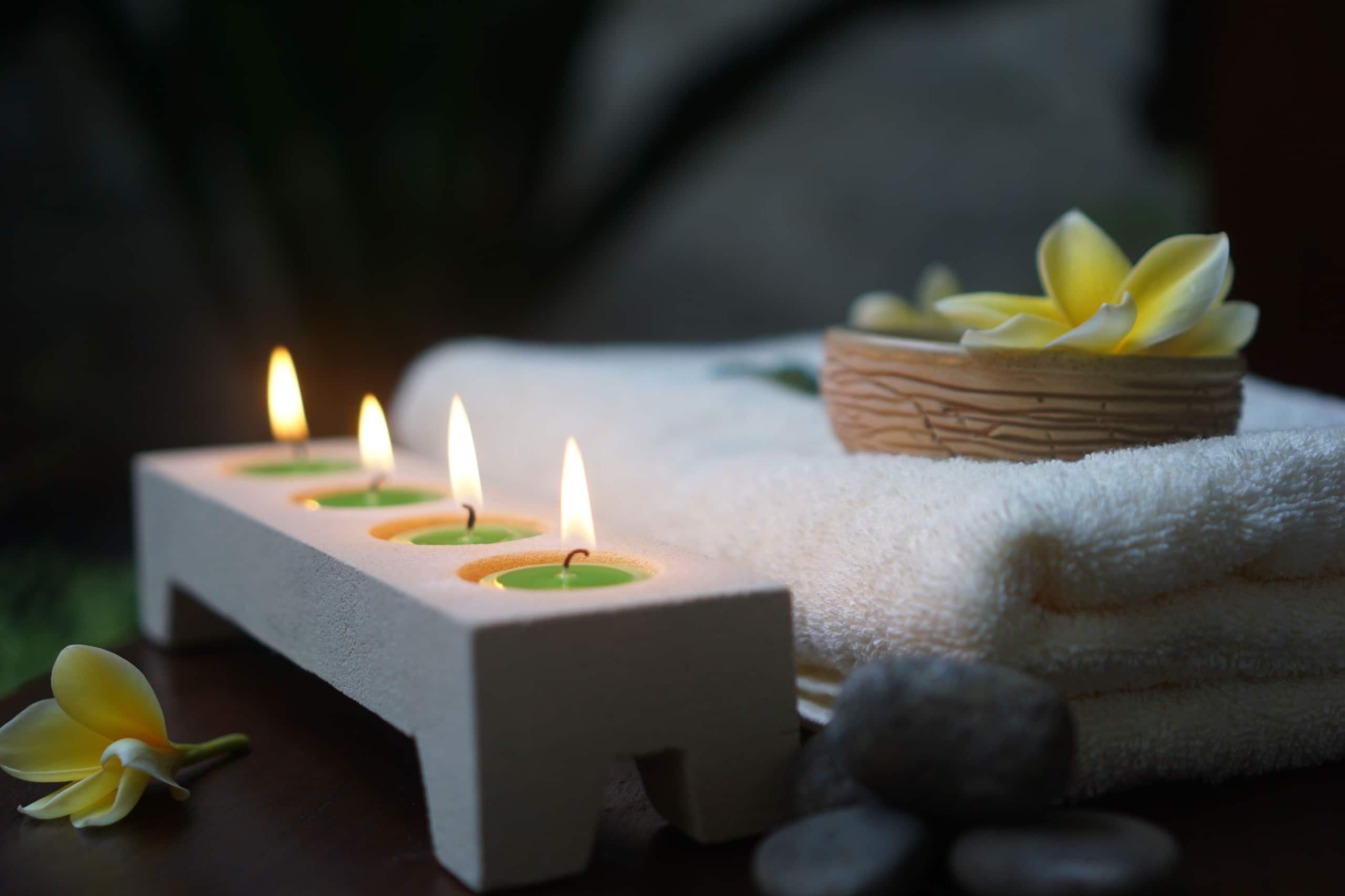 Lit candles and white flowers arranged for an evening treatment