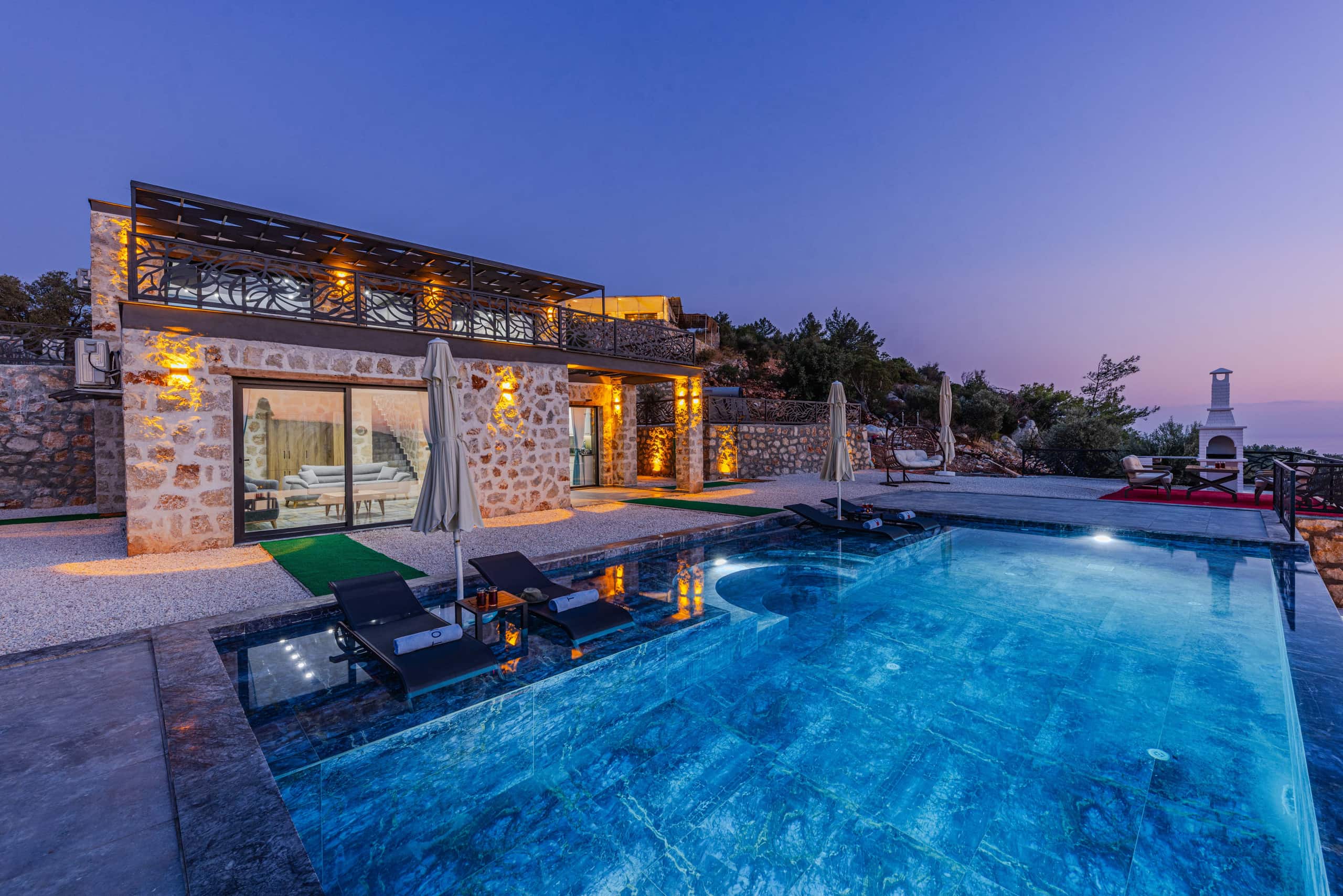 Stone villa and pool glowing quietly at twilight