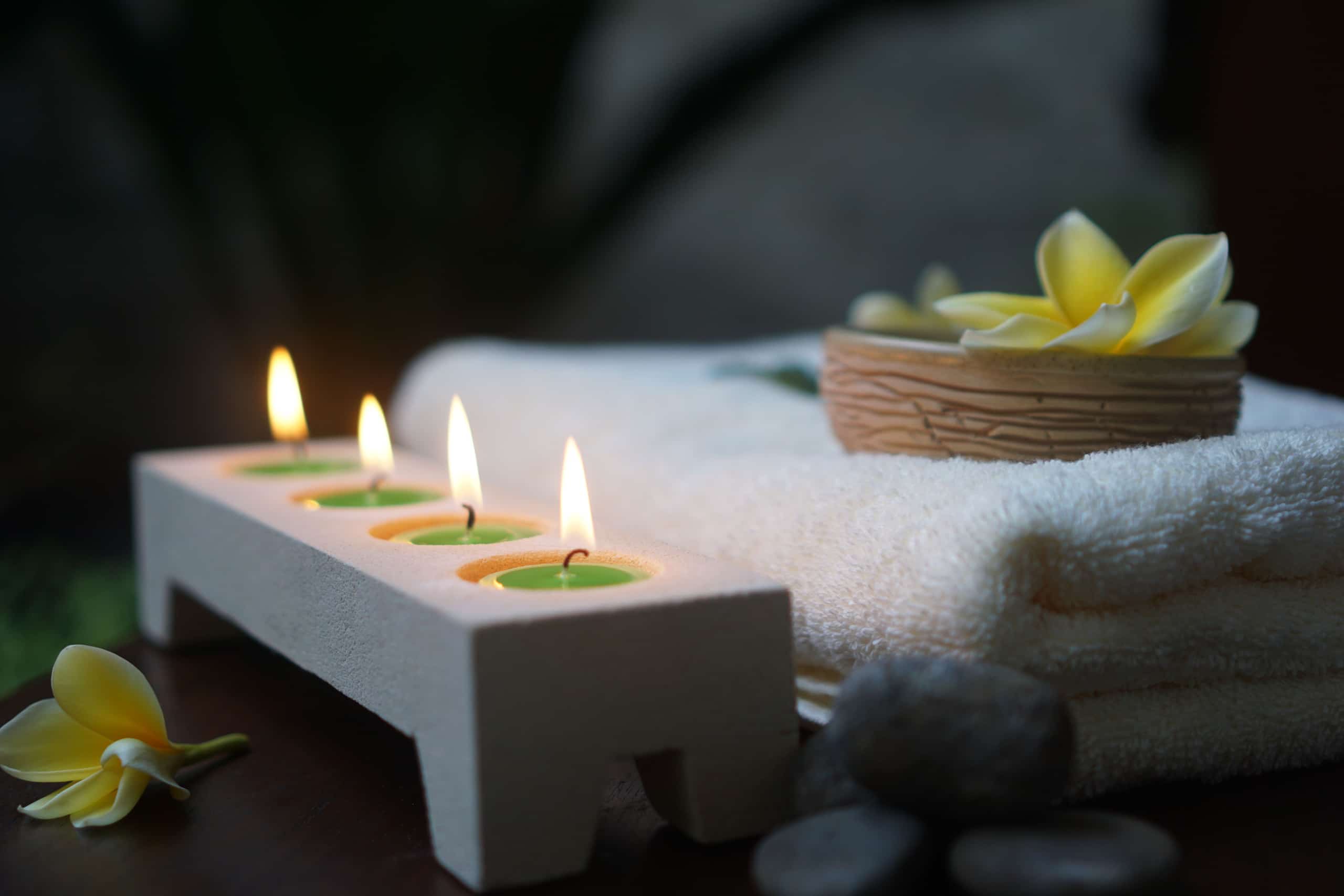 Candlelit trays casting warm light across the stone spa interior
