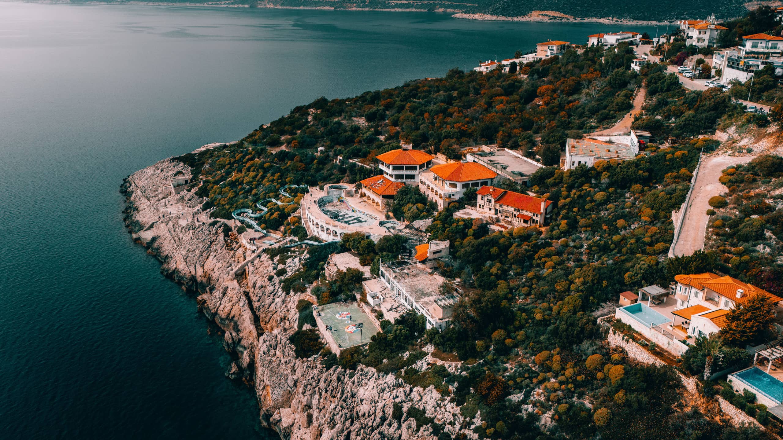 Aerial view of whitewashed villas descending the Mediterranean cliffside